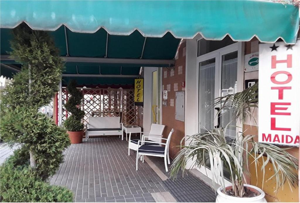 un patio con sedie e piante di fronte a un negozio di HOTEL MAIDA a Follonica