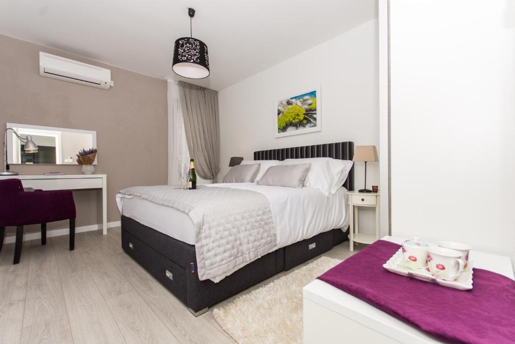 a bedroom with a large white bed and a desk at Adriatic Blue View in Split