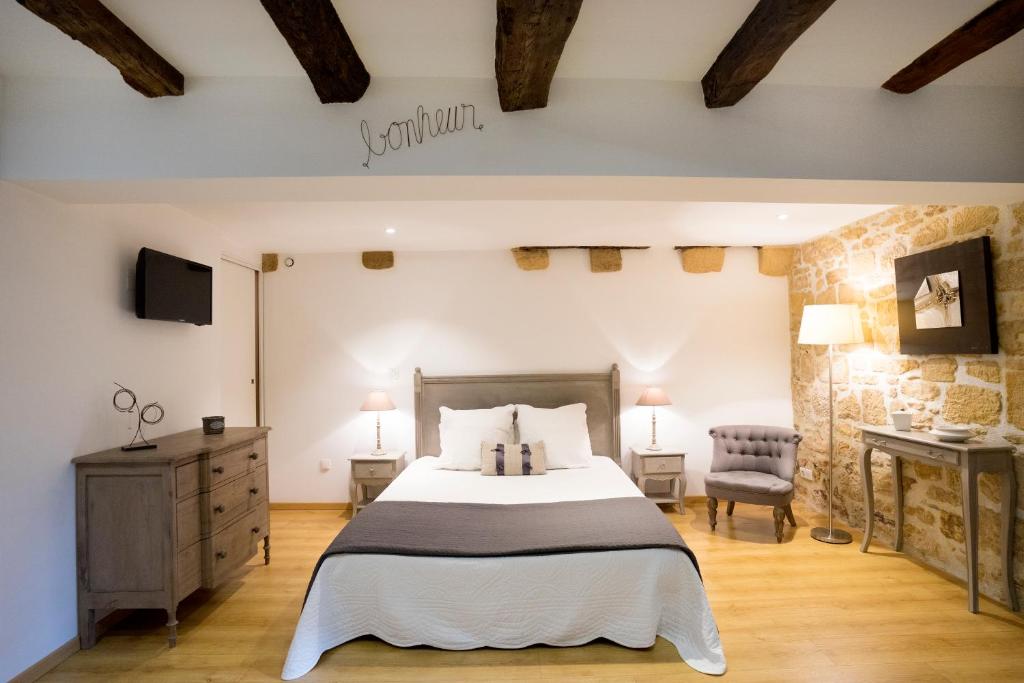 sypialnia z dużym łóżkiem i kamienną ścianą w obiekcie La Petite Salamandre w mieście Sarlat-la-Canéda