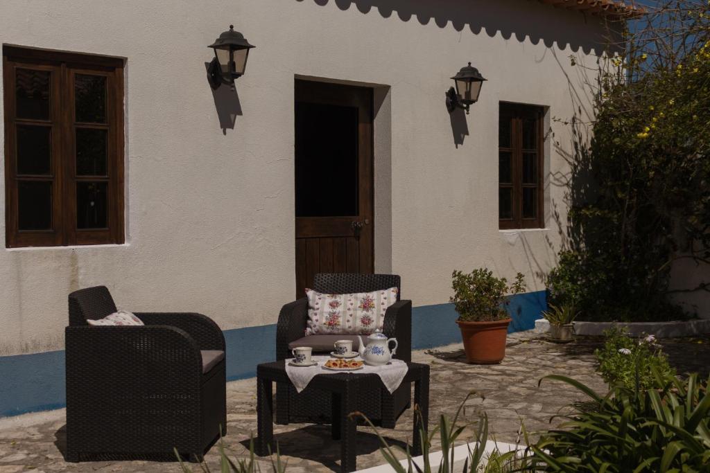due sedie e un tavolo di fronte a una casa di Casa Rústica a Serra do Bouro