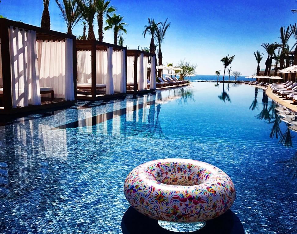 a swimming pool with a float in the water at Chileno Bay Resort & Residences, Auberge Resorts Collection in Cabo San Lucas