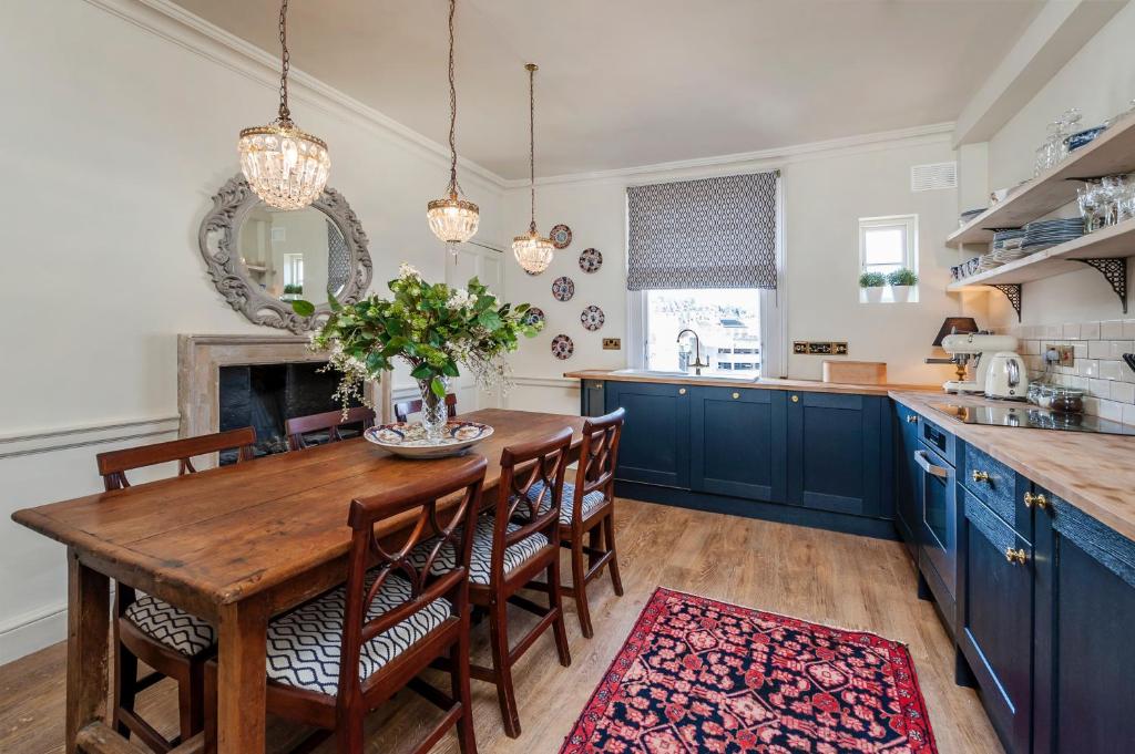 a kitchen with a wooden table and blue cabinets at Luxury Regency Apartment in Bath City Centre in Bath