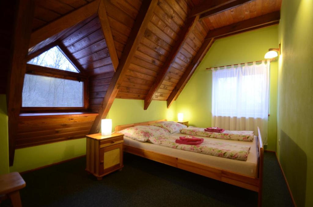 1 dormitorio con 1 cama en una casa de madera en Salas-Partizanske, en Partizánske
