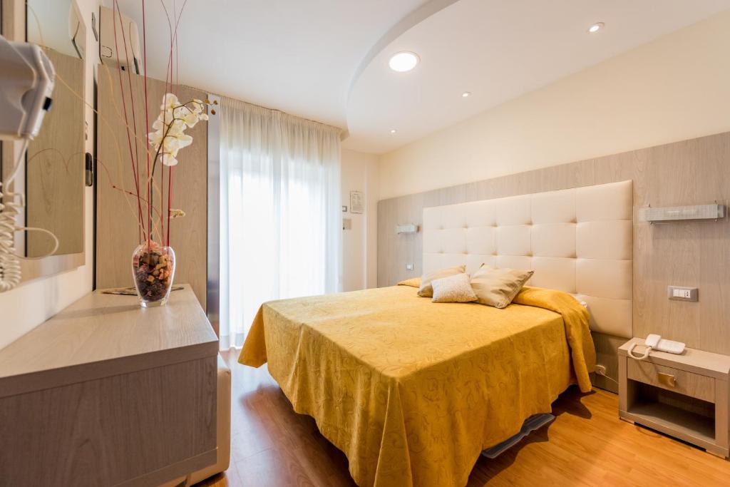 ベッラーリア・イジェア・マリーナにあるHotel Atlanticのベッドルーム1室(黄色のベッドカバー付)