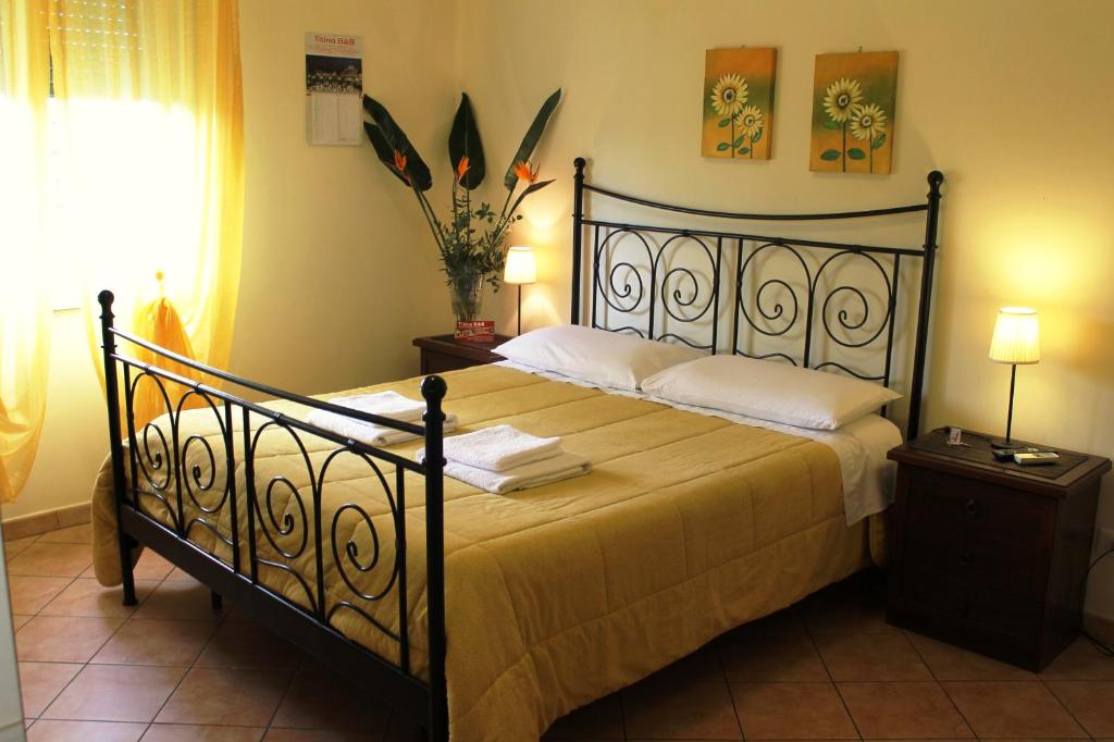 sypialnia z dużym łóżkiem z czarną ramą w obiekcie Titina B&B w Rzymie