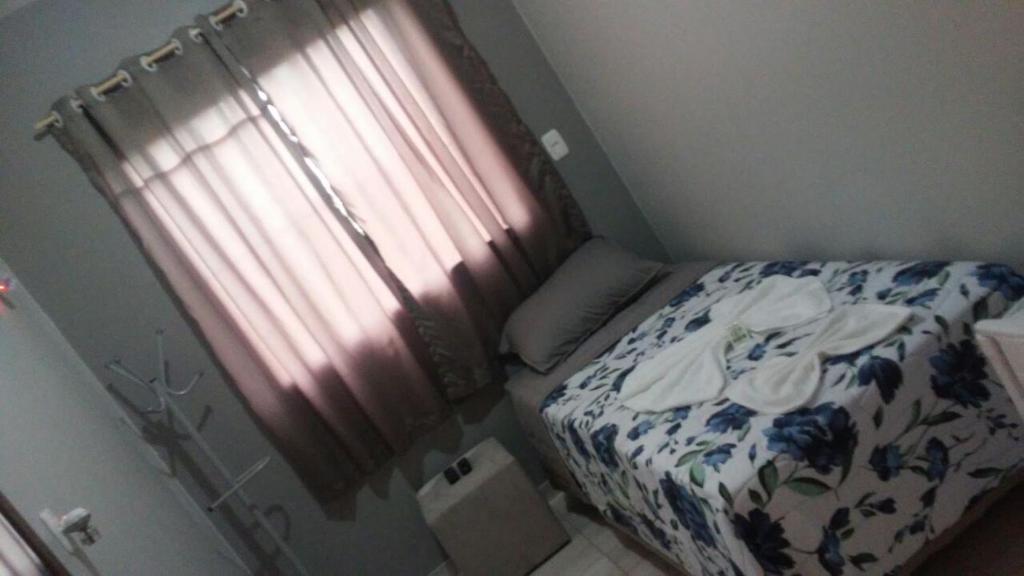 a small bedroom with a bed and a window at Aquariu's Pousada e Restaurante in Cêrro Negro
