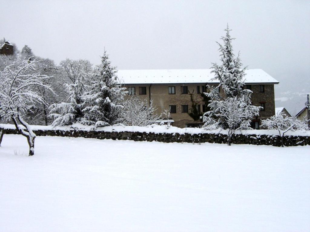 a snow covered yard in front of a building at L'Orri del Pallars in Montardit