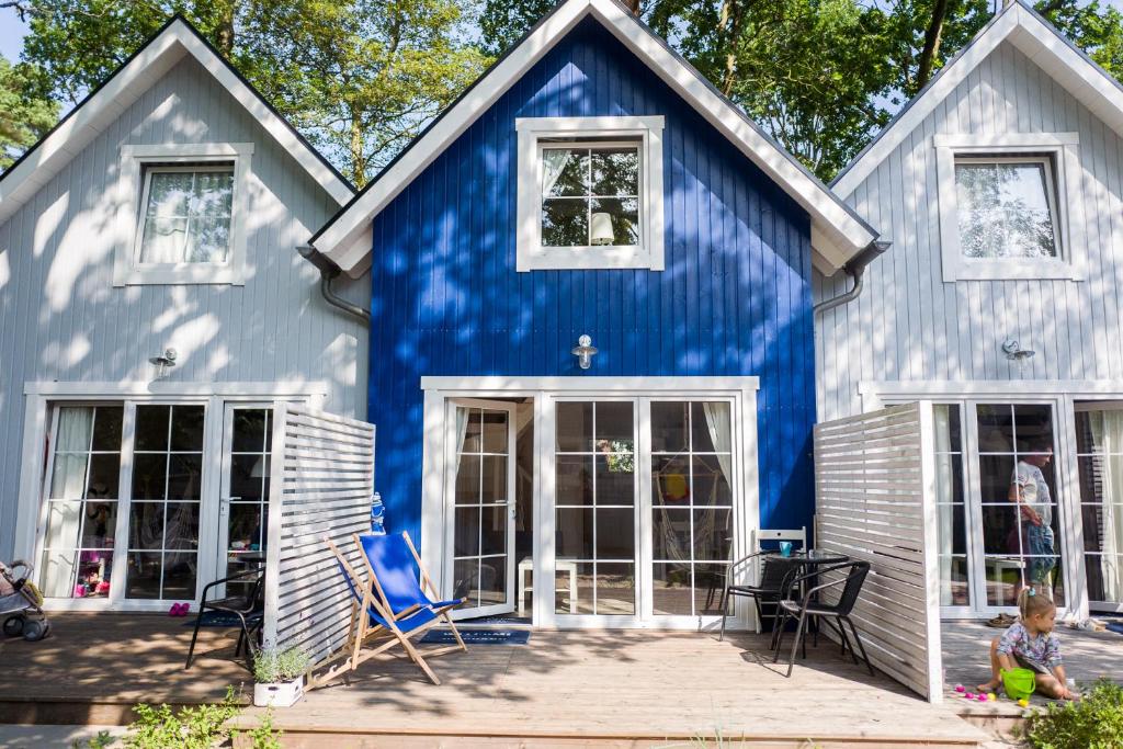 a blue and white house with a patio at Marynarskie Domki in Pobierowo