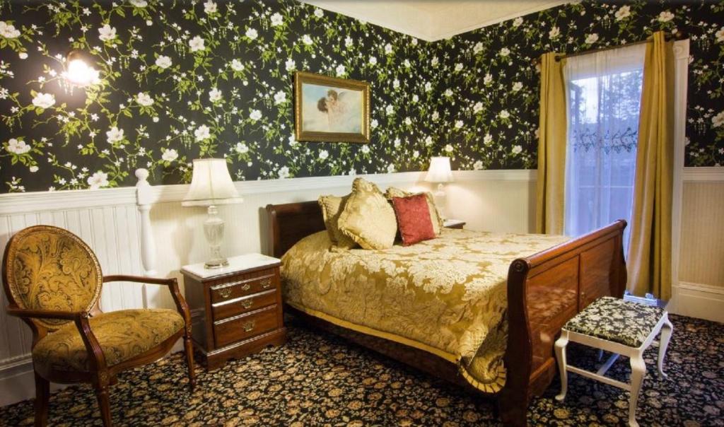 a bedroom with a bed and a chair at Gingerbread Mansion in Ferndale