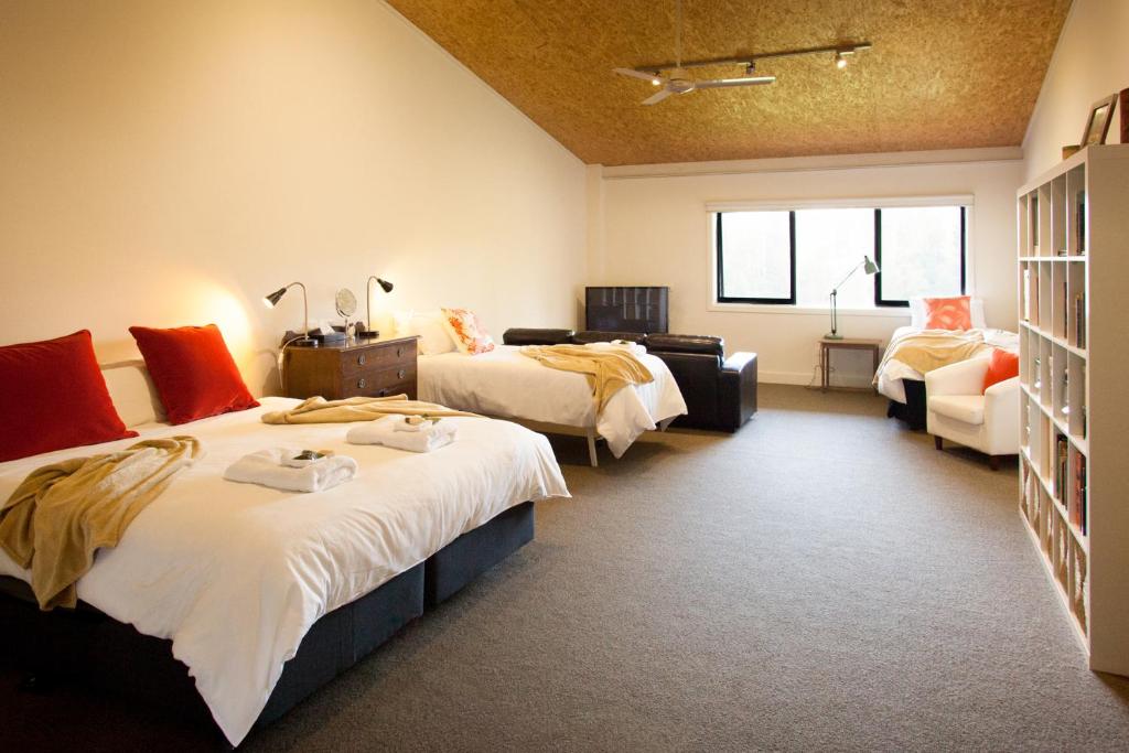 um quarto de hotel com duas camas e um sofá em Saladin Lodge em Narbethong