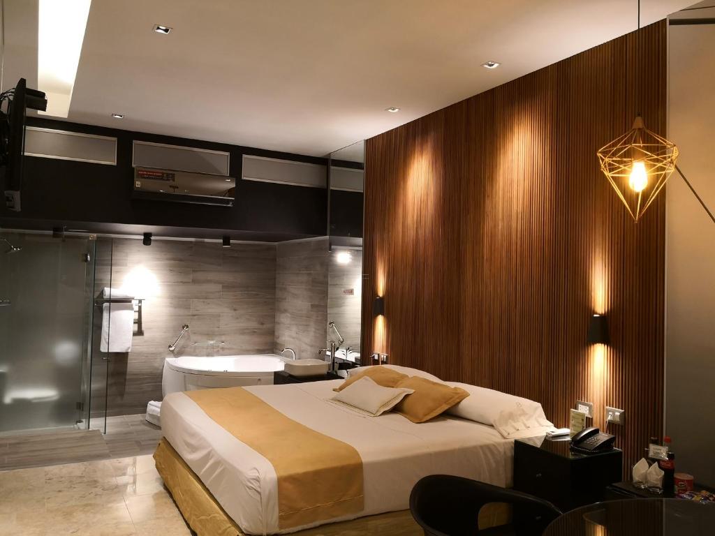 1 dormitorio con cama, bañera y lavamanos en Hotel Las Lomas en Lima