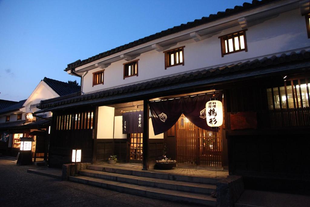 un edificio con una señal delante de él en Ryori Ryokan Tsurugata en Kurashiki