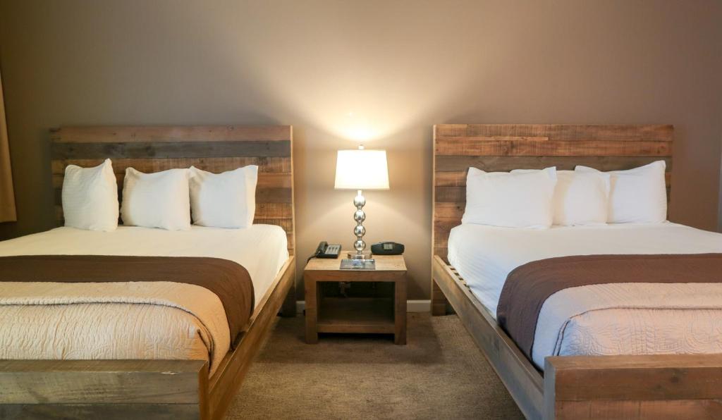 ein Hotelzimmer mit zwei Betten und einem Tisch mit einer Lampe in der Unterkunft Thunderbird Boutique Hotel in Las Vegas