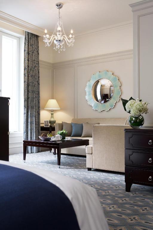 a living room with a bed and a chandelier at The Tokyo Station Hotel in Tokyo