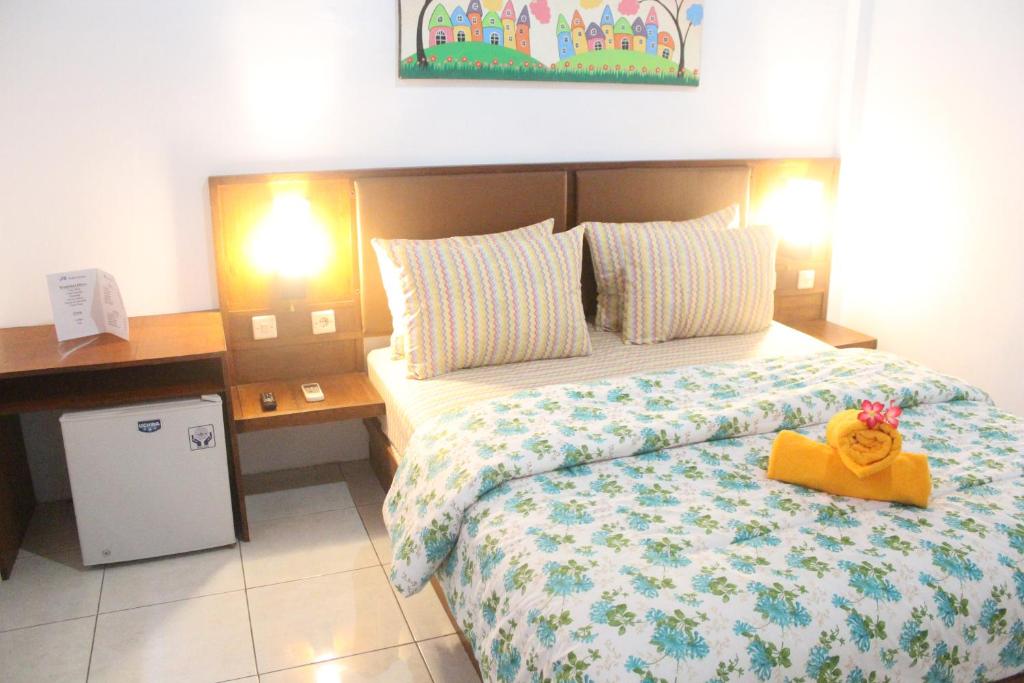 ein Schlafzimmer mit einem Bett mit einem Teddybär drauf in der Unterkunft JS Guest House in Seminyak