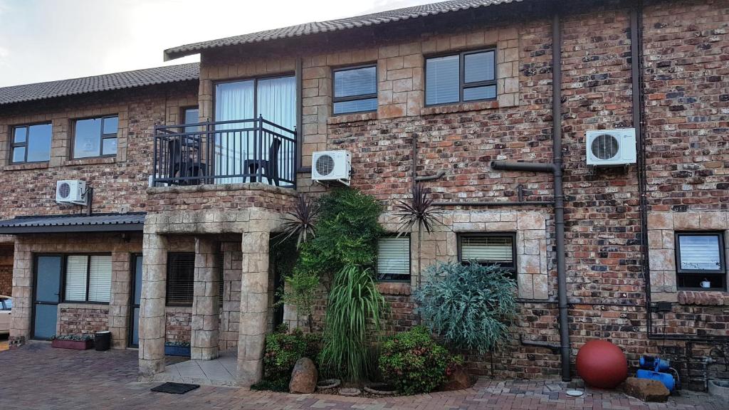 un edificio de ladrillo con plantas a su lado en Tsessebe Guesthouse en Bloemfontein