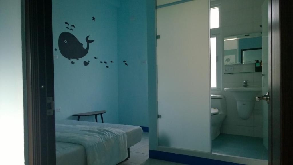 a bathroom with a bedroom with a bird stencil on the wall at Da Peng Bay Homestay in Linbian