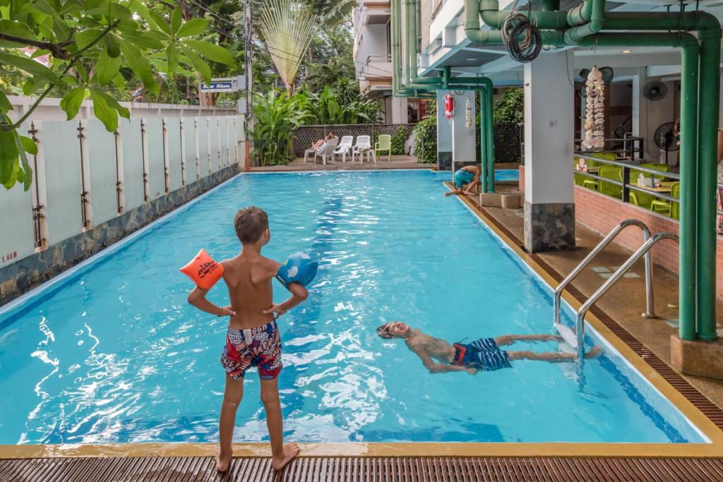 zwei Kinder spielen im Pool eines Hotels in der Unterkunft New Siam II - SHA Certified in Bangkok