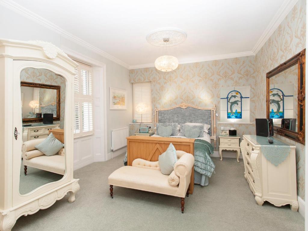 a bedroom with a bed with a mirror and a desk at The Somerville in Torquay