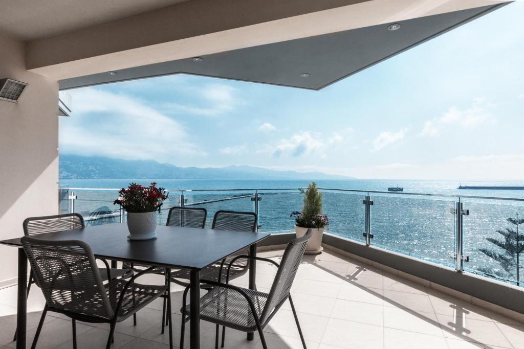 una mesa y sillas en un balcón con vistas al océano en DN Sea Apartments en Kalamata