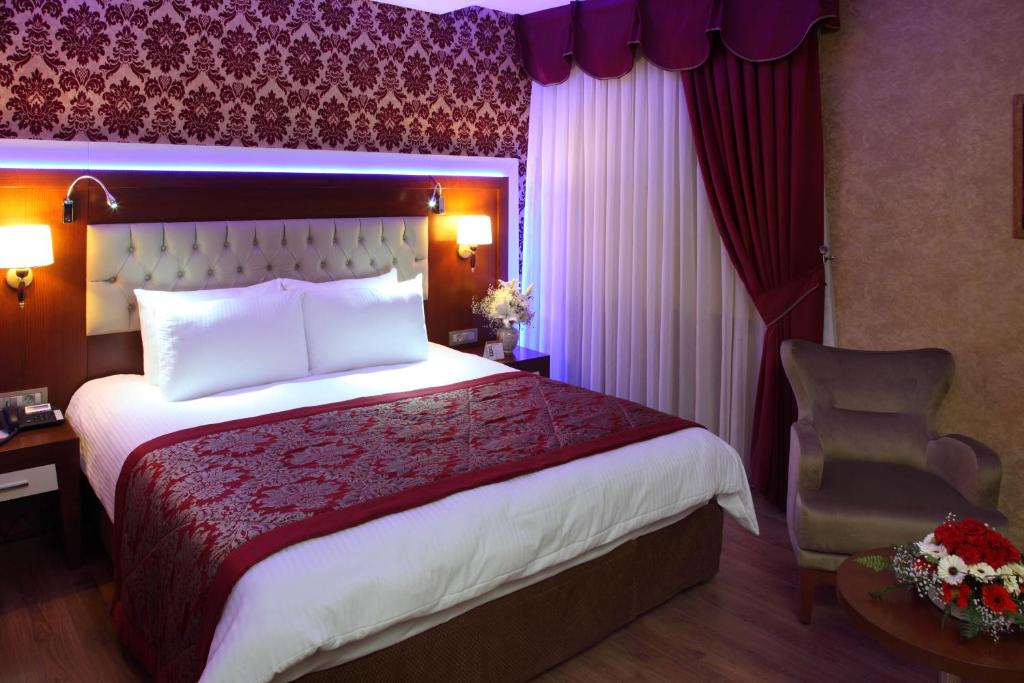 a hotel room with a bed and a chair at Hotel Senbayrak City in Adana