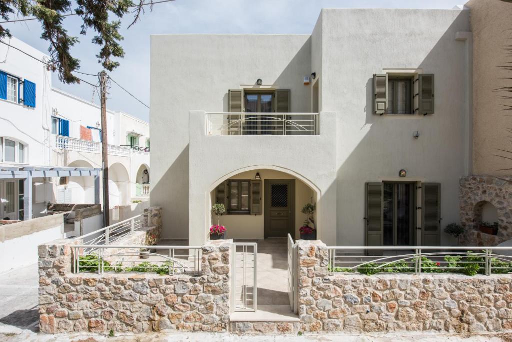 a white house with a stone wall at Platinum in Kamari