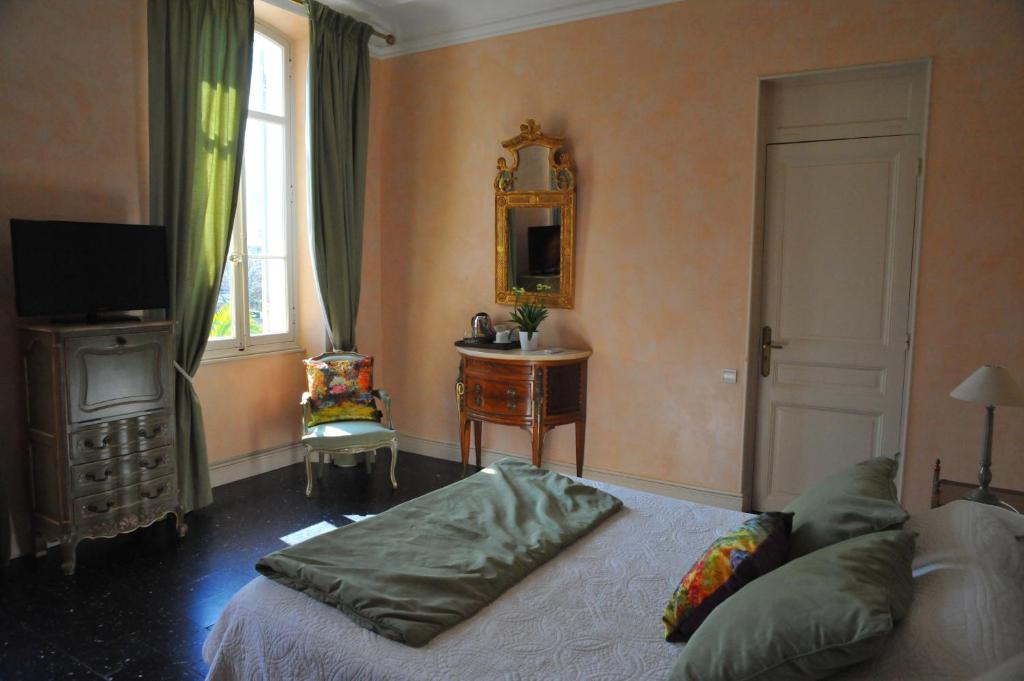 a bedroom with a bed and a table and a mirror at Villa Valflor chambres d'hôtes et appartements in Marseille