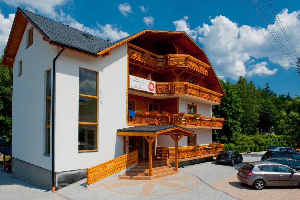 ein großes weißes Gebäude mit einem großen Balkon in der Unterkunft Willa Alpejska in Wisła