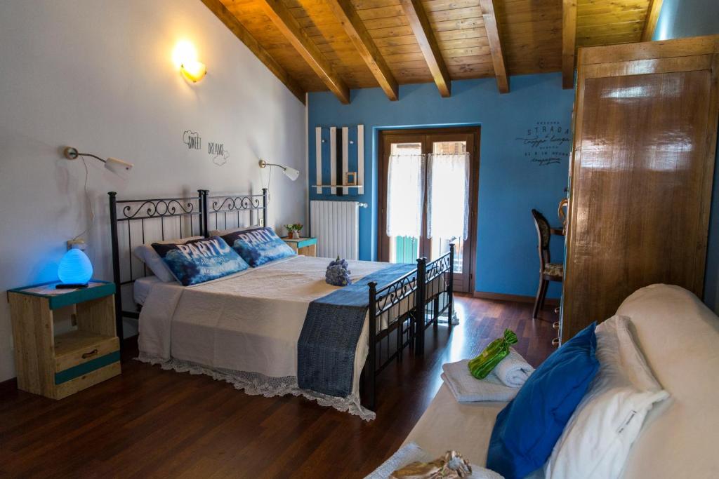 San Colombano al Lambro的住宿－B&B Amici del Colle，一间设有床铺的卧室,位于一间拥有蓝色墙壁的房间