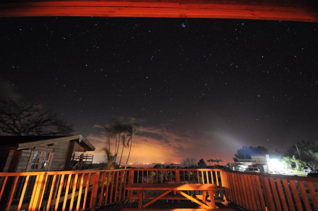 una noche estrellada con una mesa de picnic en una cubierta en Pension Yonaha Dake, en Kunigami