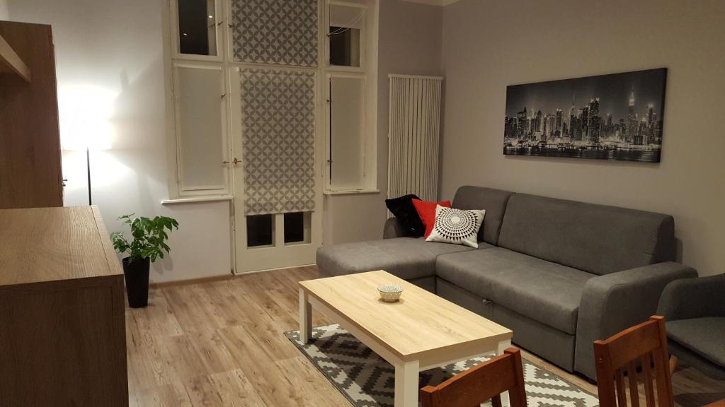 Apartament w Starej Kamienicy في بوزنان: غرفة معيشة مع أريكة وطاولة