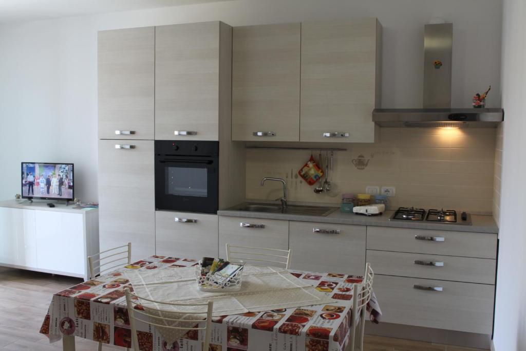 a kitchen with a table and a sink and a stove at Residenza Somma in Sommacampagna