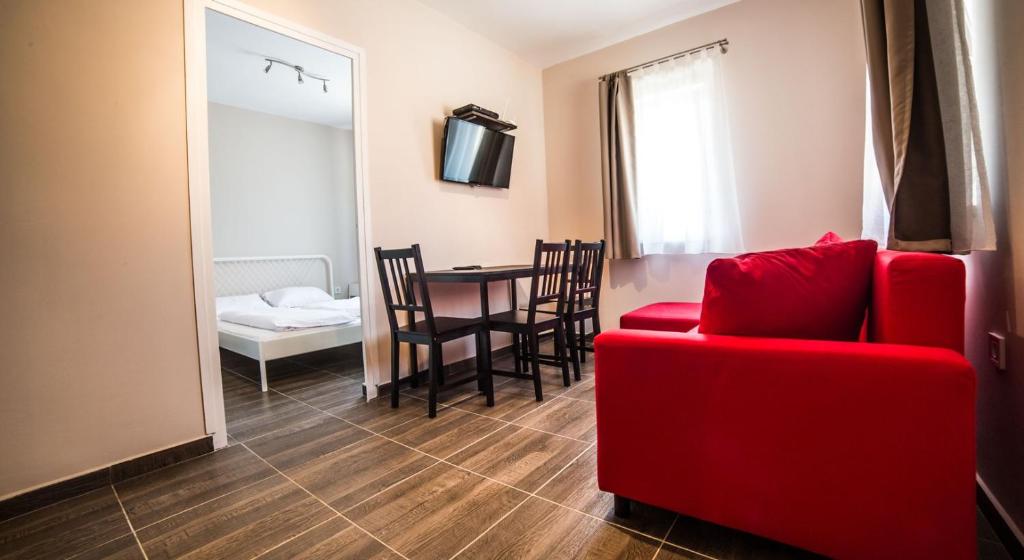 salon z czerwoną kanapą i stołem w obiekcie Tulipán Apartman w Egerze