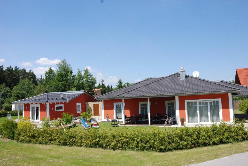 ein rotes Haus mit einem Garten davor in der Unterkunft Reiger Ferienwohnungen in Wackersdorf