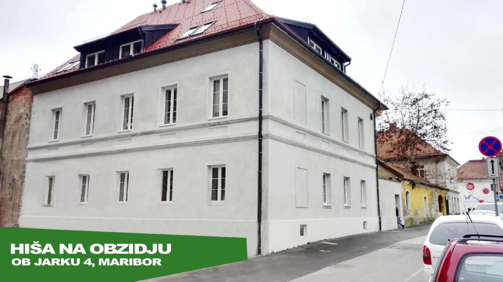 ein weißes Gebäude an der Straßenseite in der Unterkunft Bajta na obzidju in Maribor