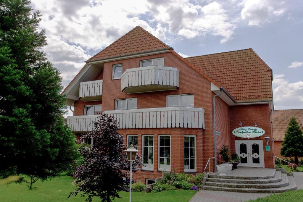 a large red brick building with a balcony at Landgasthaus Fischer in Bad Nenndorf
