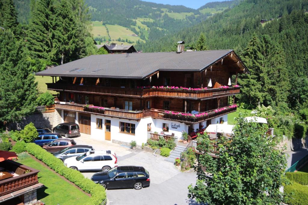 ein großes Gebäude mit Autos auf einem Parkplatz in der Unterkunft Gästehaus Gratlspitz in Alpbach