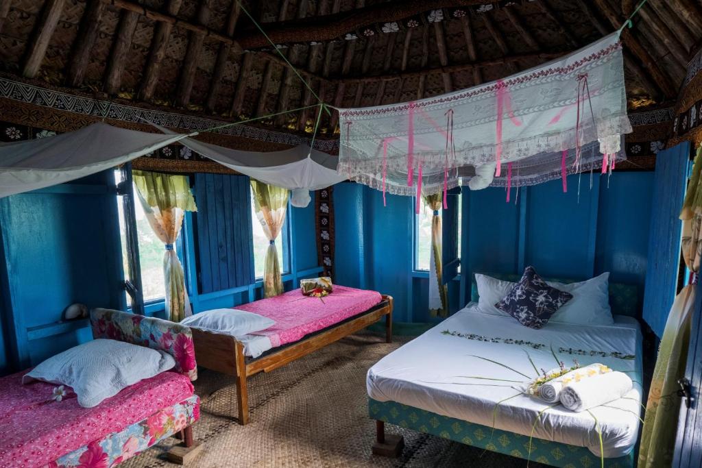 2 letti in una camera con pareti blu di Yasawa Homestays a Nacula Island