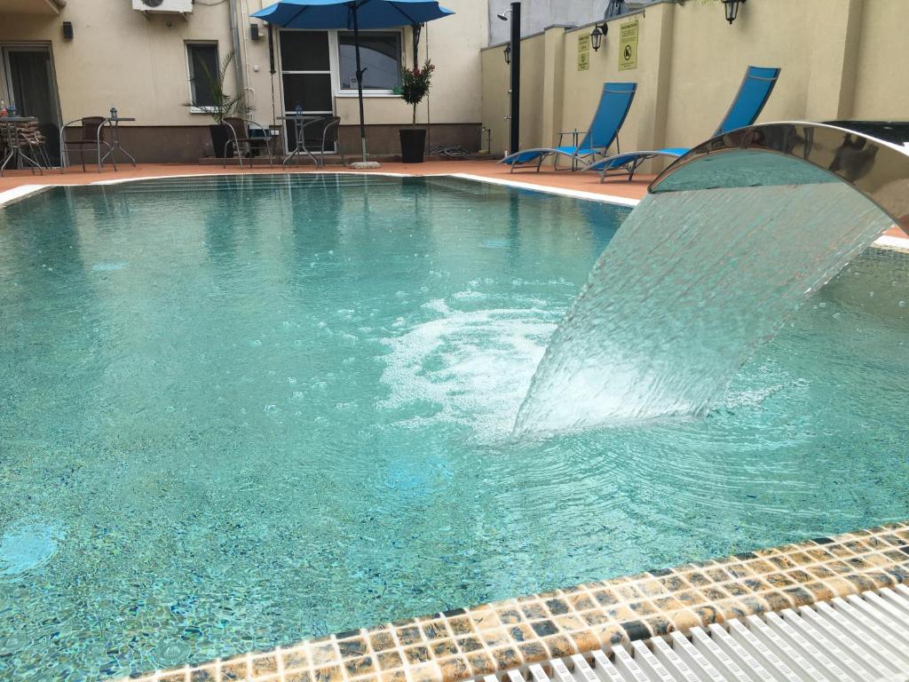 einen Pool mit einem Brunnen in einem Hotel in der Unterkunft Mosoly Apartman in Szeged