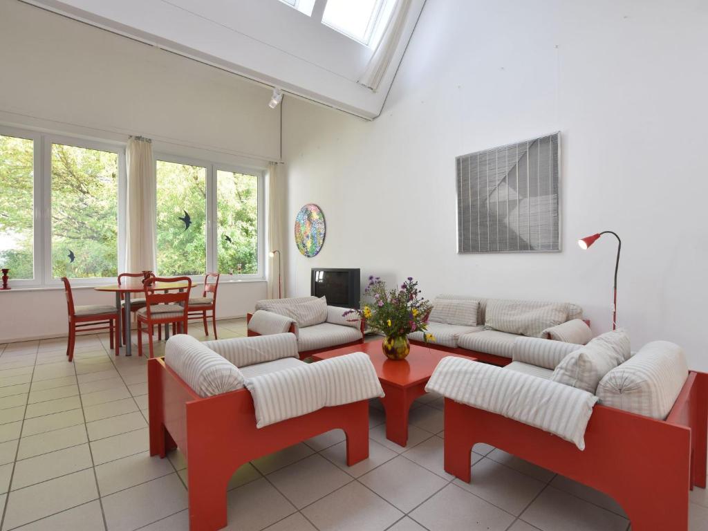 a living room with red and white furniture and a table at Ferienhaus Ostseeblick in Kühlungsborn in Kühlungsborn