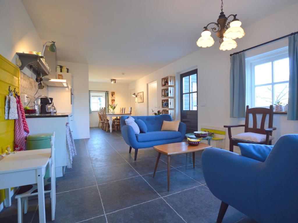 een woonkamer met blauwe banken en een tafel bij Cosy holiday home on a farm in Zeeland in Zeeland