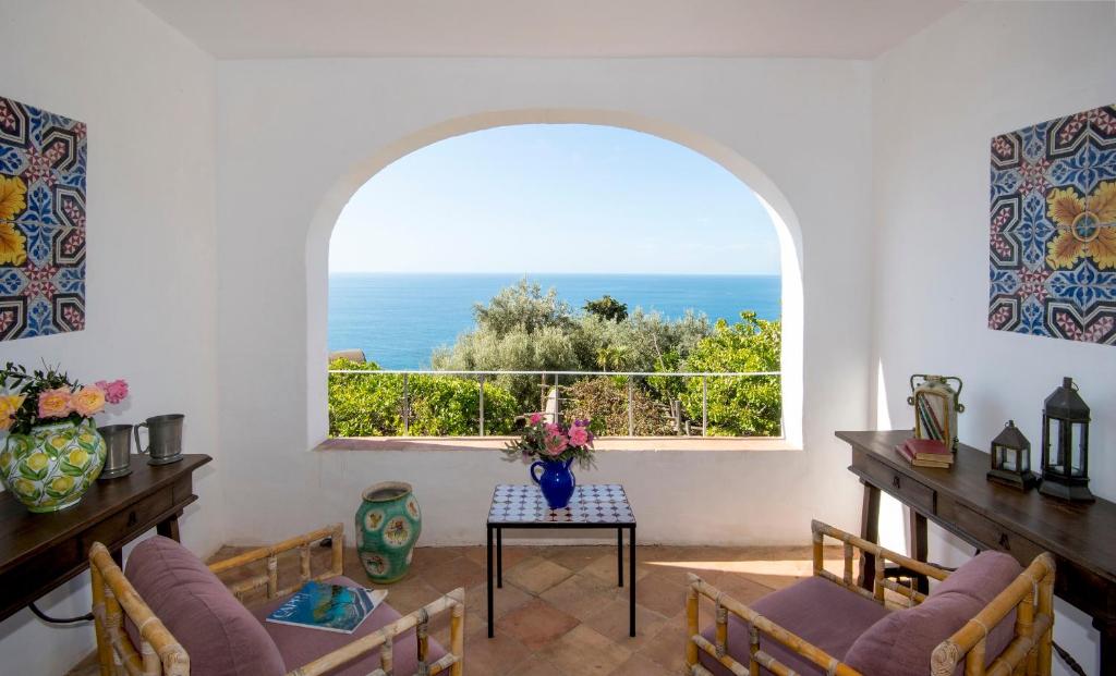 a room with a large window with a view of the ocean at Villa Lindo in Maiori