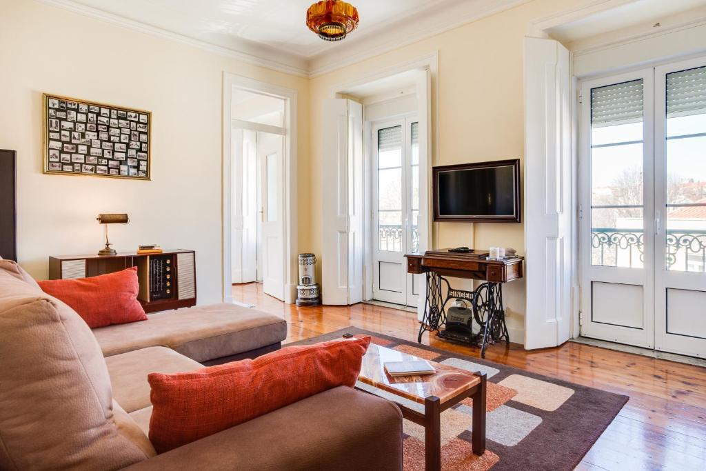 a living room with a couch and a tv at ALTIDO Fernando Pessoa Apartments in Lisbon