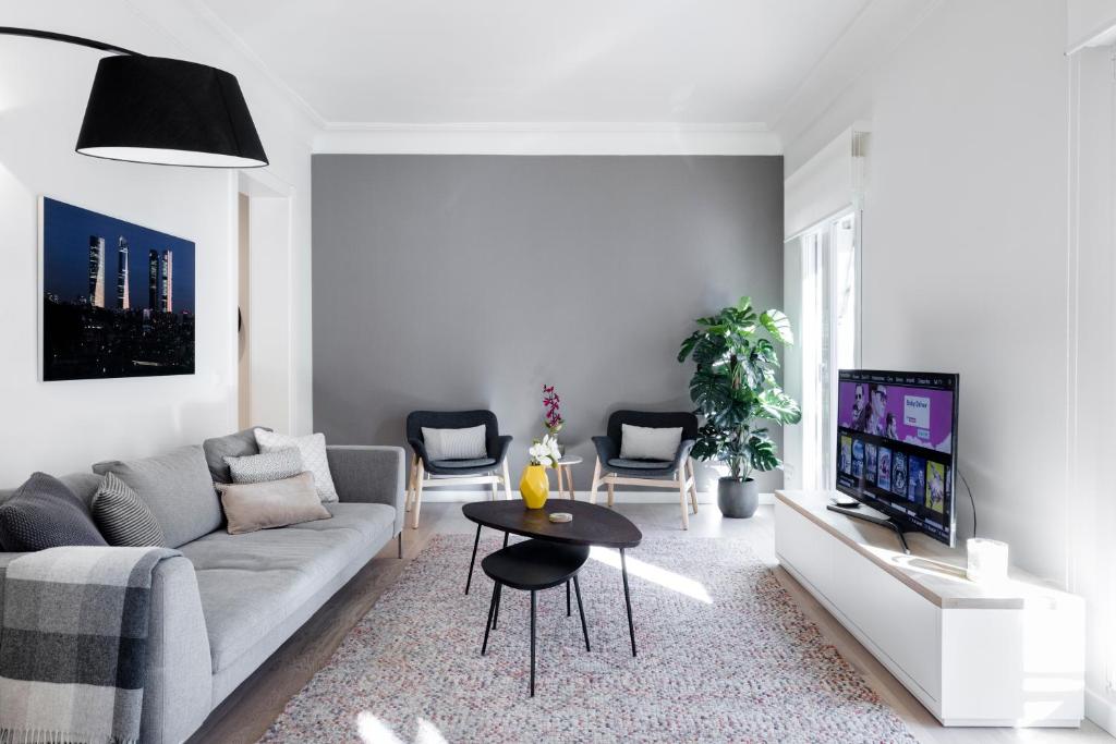 sala de estar con sofá y TV en Principe de Vergara Apartment II by Flatsweethome en Madrid