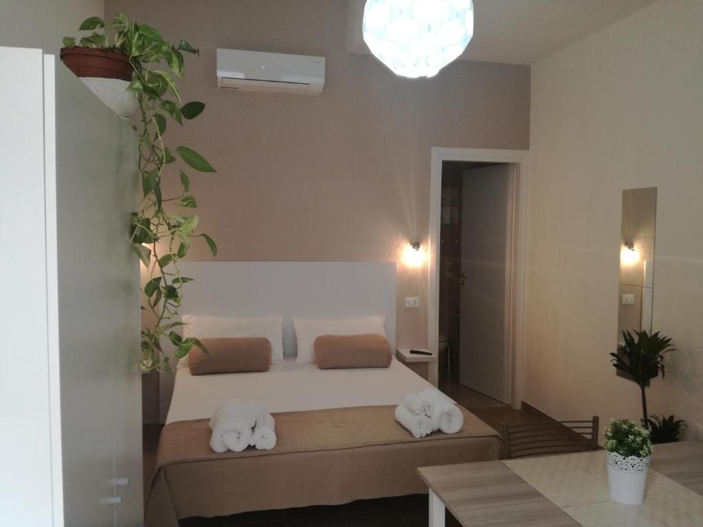 Schlafzimmer mit einem Bett mit weißer Bettwäsche und Kissen in der Unterkunft Cuore Galateo in Galatone