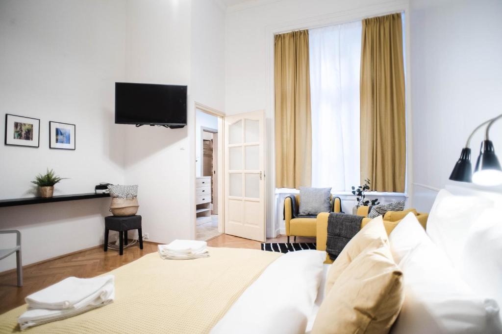 ブダペストにあるGarden Trees Apartmentのベッドとリビングルームが備わるホテルルームです。