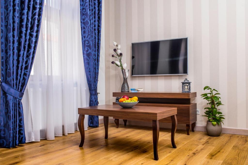 a living room with a table and a tv at Apartamenty Glamour in Żywiec