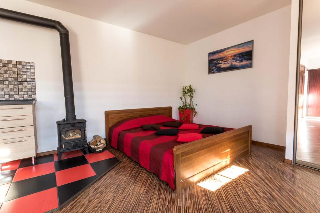 een slaapkamer met een bed en een houtkachel bij Liepāja Apartments in Liepāja