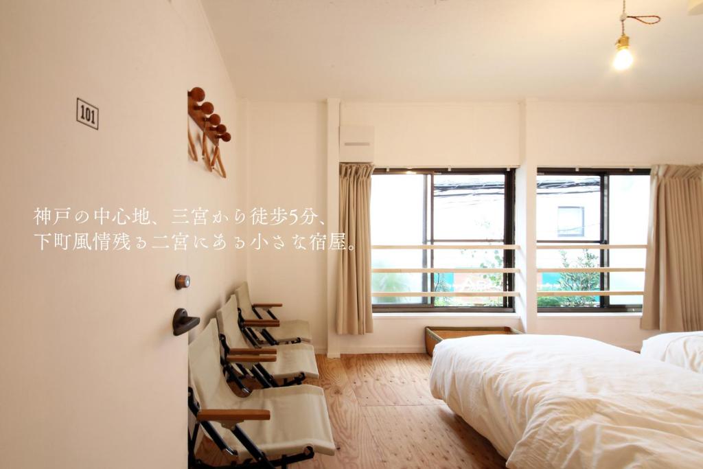 1 dormitorio con cama, sillas y ventana en 2no HOME & PARK, en Kobe