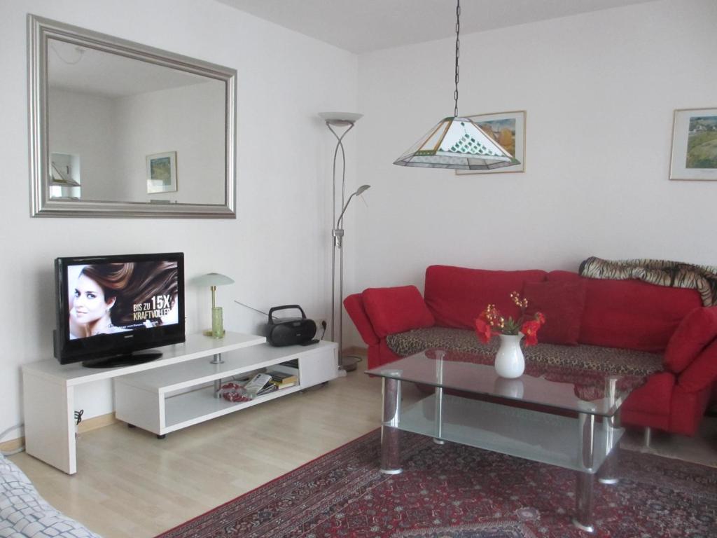 a living room with a red couch and a tv at Im Zentrum Katharinenstr. in Freiburg im Breisgau